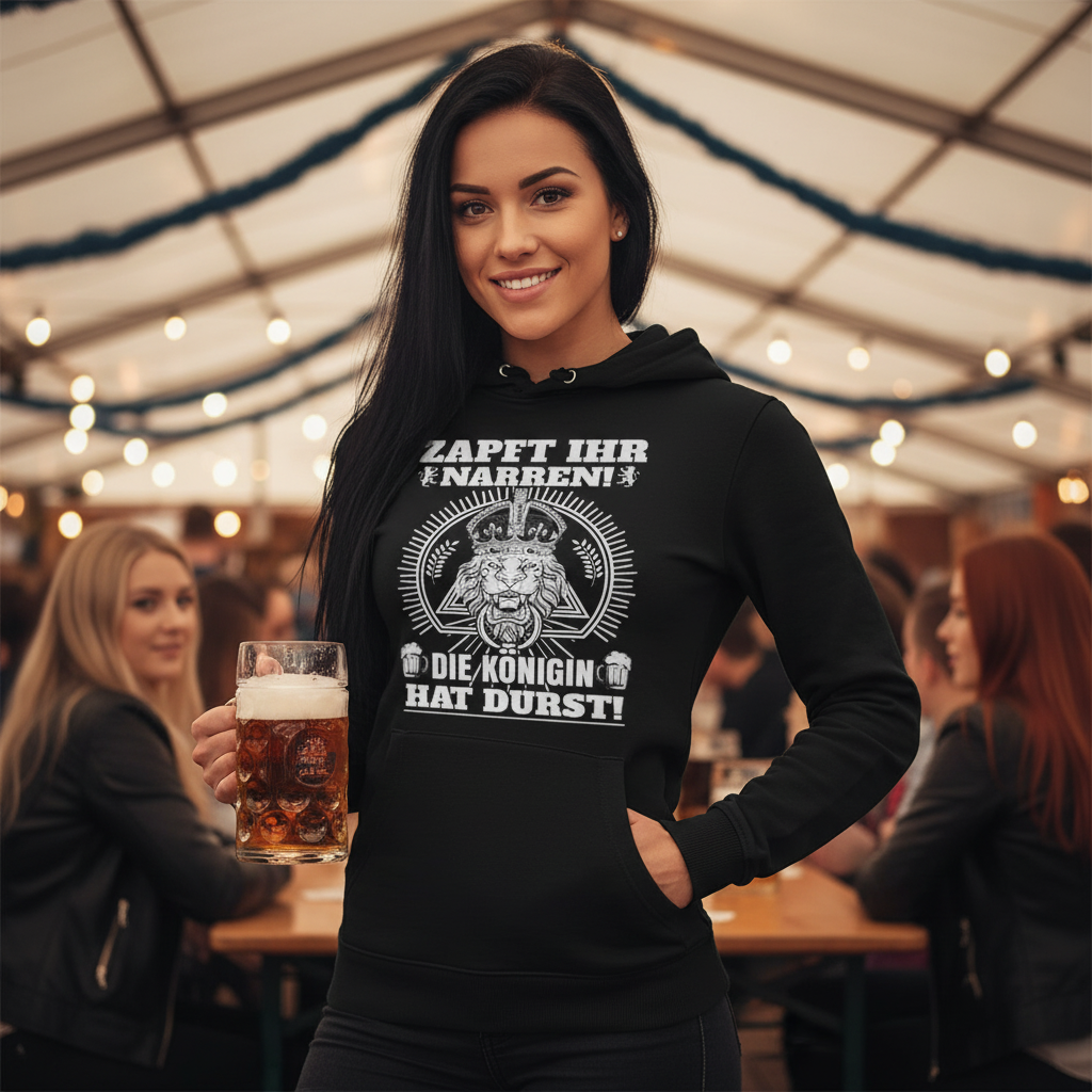 Eine Frau trägt den Zapft ihr Narren Hoodie im Oktoberfest Festzelt und hält einen Maßkrug