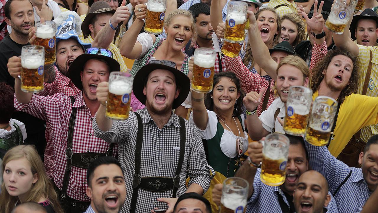 Menschen feiern und heben ihr Bier zum Gruße