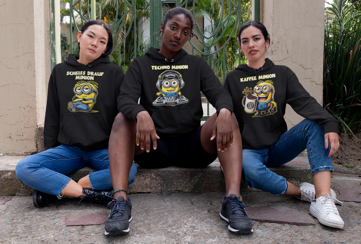 Freunde sitzen auf einer Treppenstufe und tragen witzige Minion Hoodies
