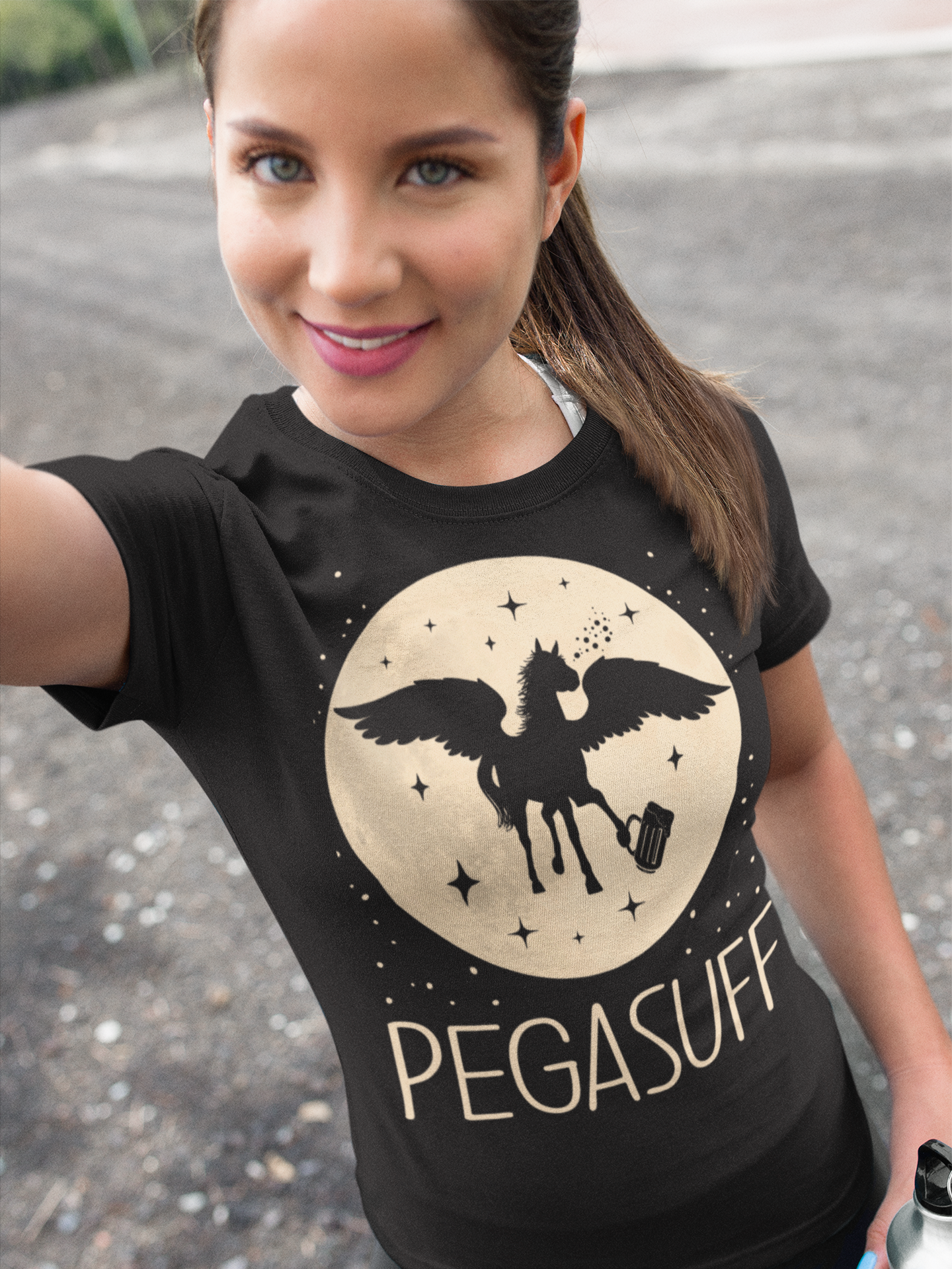 Eine Frau trägt ein Pegasus Party Shirt Pegasuff und macht ein Selfie im Freien