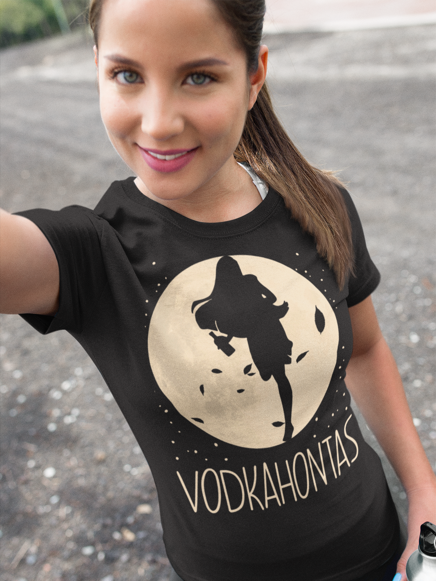 Eine Frau trägt ein VODKAHONTAS Party Shirt beim Spaziergang im Freien und macht ein Selfie