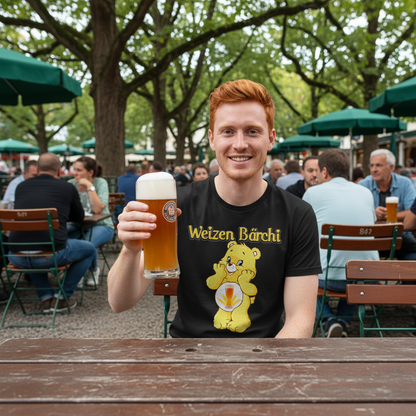 Junger Mann mit Weizen Bärchi Shirt im Biergarten, Weizenglas in der Hand, Holzbänke im Hintergrund