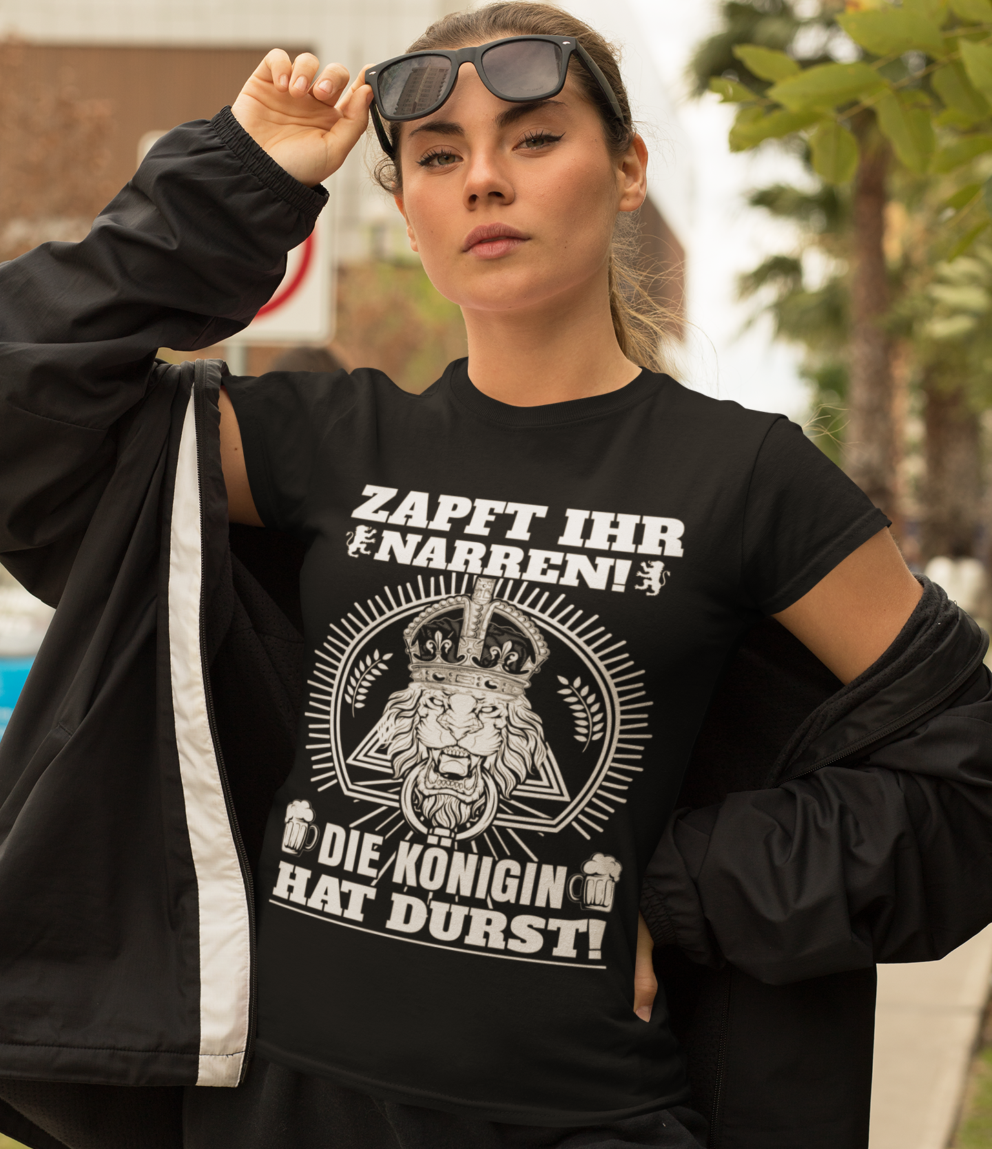 Eine Frau trägt das Zapft ihr Narren Shirt draußen und posiert mit Sonnenbrille